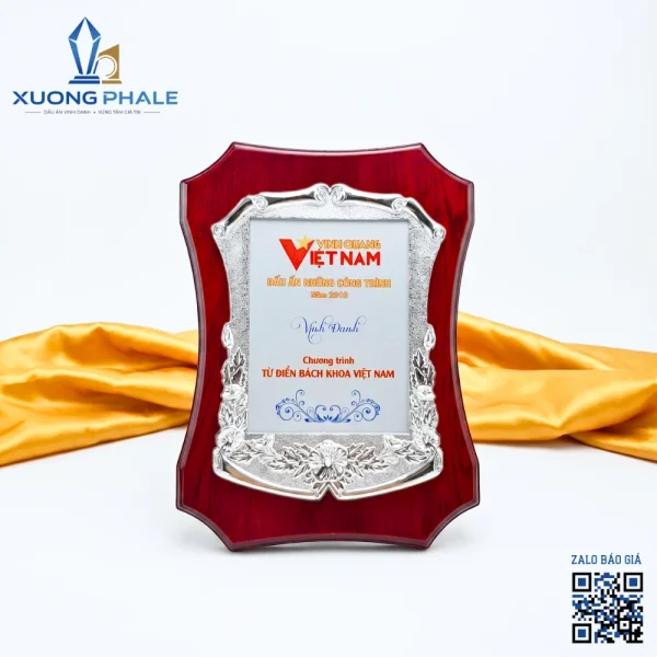 Biểu trưng gỗ đồng được chế tác cao cấp, viền mạ bạc tinh xảo, trang trọng.